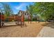 Community playground with climbing structure, swing set, and wood chip ground cover at 2654 Forest St, Denver, CO 80207