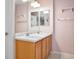Charming bathroom with double sinks, maple cabinets, and light pink walls at 11844 Oak Hill Way # A, Commerce City, CO 80640