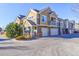 Rear view of townhome showing attached garage and additional parking at 11844 Oak Hill Way # A, Commerce City, CO 80640