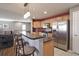This kitchen features stainless steel appliances, wooden cabinets, bar seating and a red accent wall at 11844 Oak Hill Way # A, Commerce City, CO 80640