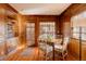 An eat-in dining area is surrounded by wood paneling, and enjoys natural light from multiple windows at 5555 E 17Th Avenue Pkwy, Denver, CO 80220