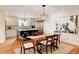 Kitchen and dining area with large island, stainless appliances, wood floors, and natural light at 5555 E 17Th Avenue Pkwy, Denver, CO 80220