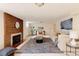 Open living room featuring a brick fireplace, neutral furniture, and a stylish modern rug at 5555 E 17Th Avenue Pkwy, Denver, CO 80220