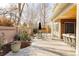 A covered patio with an outdoor dining area is surrounded by greenery, a brick wall, and flower planters at 5555 E 17Th Avenue Pkwy, Denver, CO 80220