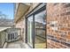 Balcony with brick wall, sliding glass doors, and wooden railing at 6475 S Dayton St # 102, Englewood, CO 80111