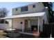 Charming two-story home featuring a covered front porch, white siding, and a metal roof at 3355 S Logan St, Englewood, CO 80113