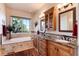 Bright bathroom with double vanity, granite countertop, soaking tub, and large window at 8002 Galileo Way, Littleton, CO 80125
