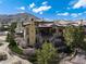 Expansive two-story home with stone and stucco accents, mountain views, and manicured landscaping at 8002 Galileo Way, Littleton, CO 80125