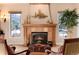 Cozy fireplace with detailed mantle, flanked by bright windows and decorative accents at 8002 Galileo Way, Littleton, CO 80125