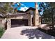 A beautiful stone home featuring a two-car garage and a long driveway at 8002 Galileo Way, Littleton, CO 80125