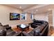 Cozy living room featuring plush leather seating, large windows, and a mounted television at 8002 Galileo Way, Littleton, CO 80125