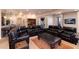 Large living room with leather furniture, a coffee table, and access to a workout area at 8002 Galileo Way, Littleton, CO 80125