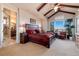 Spacious main bedroom with en-suite bathroom, wooden beams, and a scenic window view at 8002 Galileo Way, Littleton, CO 80125