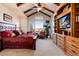 Vaulted main bedroom with wooden beams, built-in cabinetry, and scenic window view at 8002 Galileo Way, Littleton, CO 80125