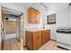 Functional basement kitchen featuring wooden cabinets, a white appliance suite, tile flooring, and ample counter space at 1563 N Lafayette St, Denver, CO 80218