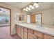 Double vanity bathroom with wood cabinets and view into bedroom at 23405 E Elmhurst Pl, Aurora, CO 80016