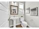 Elegant half-bathroom features a pedestal sink, framed mirror, and stylish decor at 11150 E 26Th Ave, Aurora, CO 80010