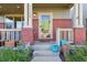 Inviting front porch with red brick pillars, plants, and a clear view of the front door at 11150 E 26Th Ave, Aurora, CO 80010