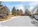 Spacious backyard with a snow-covered lawn and mature trees at 458 Whitetail Cir, Lafayette, CO 80026