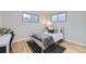 Charming bedroom featuring wood floors, bright windows, and a stylish black and white striped rug at 110 E 104Th Pl, Northglenn, CO 80233