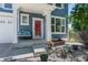 Inviting front porch with a red door, bench seating, potted plants, and white trim that adds curb appeal at 12491 E 106Th Pl, Commerce City, CO 80022