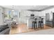 Modern kitchen with white cabinetry, stainless steel appliances, and a breakfast bar open to the dining area at 12491 E 106Th Pl, Commerce City, CO 80022
