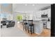 Modern kitchen and adjacent living area with stainless steel appliances, white cabinetry, and an open floor plan at 12491 E 106Th Pl, Commerce City, CO 80022