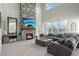 Bright living room with a floor-to-ceiling stone fireplace, comfortable seating, and large windows providing natural light at 12491 E 106Th Pl, Commerce City, CO 80022