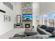 Spacious living room with a soaring stone fireplace, large windows, and comfortable seating at 12491 E 106Th Pl, Commerce City, CO 80022