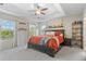 Bright main bedroom with large bed, neutral walls, plenty of natural light, and shelving at 12491 E 106Th Pl, Commerce City, CO 80022