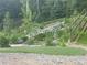 Landscaped backyard with rock retaining wall, stairs, artificial turf and natural foliage creates a serene outdoor space at 1345 Witter Gulch Rd, Evergreen, CO 80439