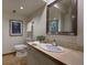 Well-lit bathroom featuring a vanity with sink, mirror, toilet, and decorative artwork for a serene ambiance at 1345 Witter Gulch Rd, Evergreen, CO 80439