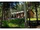 Exterior view of a wood home featuring mature trees and grassy area at 1345 Witter Gulch Rd, Evergreen, CO 80439