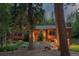 Charming wood and stone home featuring mature trees, front bench, and lovely landscaping at 1345 Witter Gulch Rd, Evergreen, CO 80439