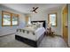 Bright main bedroom with plush carpeting, ceiling fan, and two large windows at 1345 Witter Gulch Rd, Evergreen, CO 80439