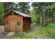 Exterior of wood outbuilding, set amongst lush greenery and trees offering versatile outdoor space at 1345 Witter Gulch Rd, Evergreen, CO 80439