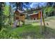 Backyard playground set including swings and slide with the house in the background at 1345 Witter Gulch Rd, Evergreen, CO 80439