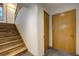 Stairway featuring wood stairs, wood railing, tile flooring, and access to storage closet at 1345 Witter Gulch Rd, Evergreen, CO 80439
