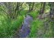 Backyard stream surrounded by lush green grass at 1345 Witter Gulch Rd, Evergreen, CO 80439
