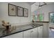Wet bar boasts granite countertops, mosaic backsplash, and views of wooded backyard at 1345 Witter Gulch Rd, Evergreen, CO 80439