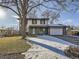 Ranch style home with gray brick and white siding, a blue door, and a landscaped yard at 5285 Gladiola St, Arvada, CO 80002