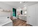 Bright bathroom featuring a soaking tub, dual vanity, and stylish wood-look flooring at 199 Simmental Loop, Castle Rock, CO 80104