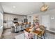 A open concept kitchen with an island, bar stools and a dining table with pink chairs at 199 Simmental Loop, Castle Rock, CO 80104