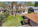 Charming two-story home with a well-manicured backyard, a spacious deck, a lovely lawn, and mature trees at 1215 S Ogden St, Denver, CO 80210