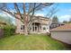 A spacious backyard featuring a large lawn, mature trees, a deck with outdoor furniture, and a two-story home at 1215 S Ogden St, Denver, CO 80210