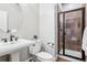 Compact bathroom features a stand-up shower, pedestal sink, a toilet, and modern fixtures at 1215 S Ogden St, Denver, CO 80210