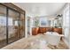 Open bathroom with large glass shower, soaking tub, and wooden vanity with stone countertop at 1215 S Ogden St, Denver, CO 80210