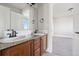 Bathroom featuring double sinks with granite counters and wood cabinets with tile flooring at 1215 S Ogden St, Denver, CO 80210