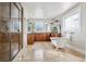 Spacious bathroom boasts a luxurious soaking tub, glass block window, and stone countertop vanity at 1215 S Ogden St, Denver, CO 80210