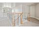 Upstairs hallway features wooden railing, neutral walls, and soft carpet for a bright and airy transitional space at 1215 S Ogden St, Denver, CO 80210